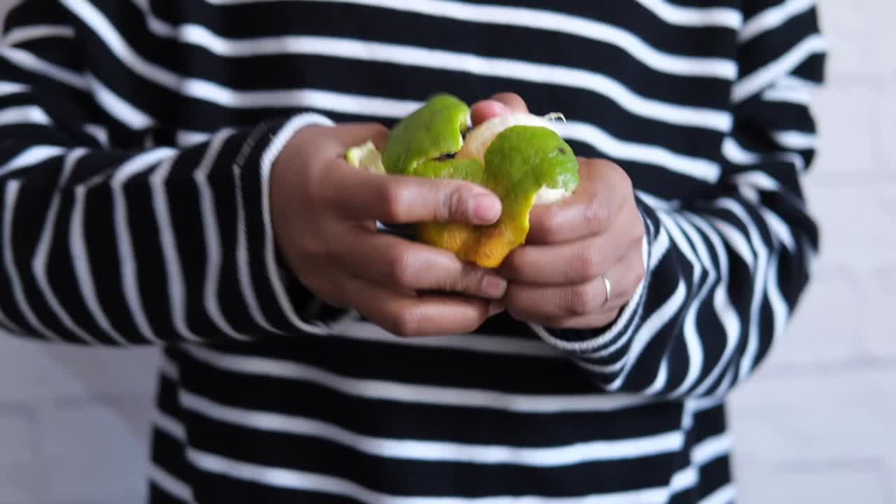 hombres jóvenes quitando la piel de una naranja