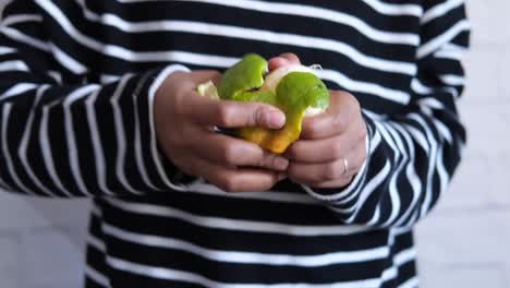 young men taking skin off from a orange