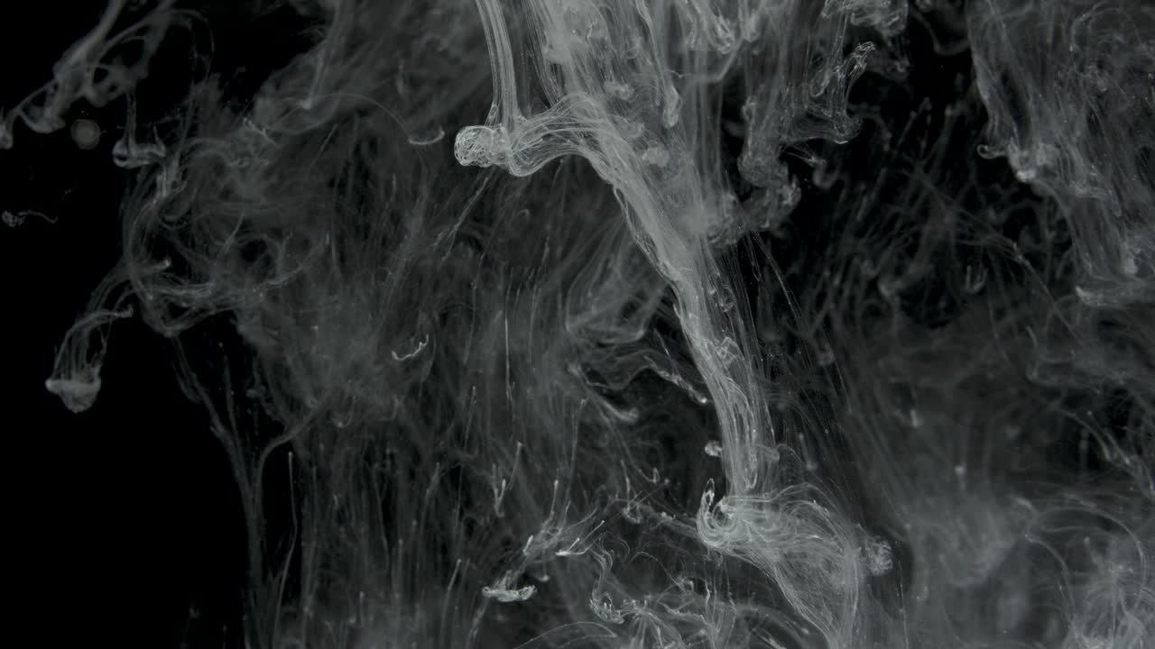 Effetto inchiostro bianco nell'acqua filmato su sfondo nero