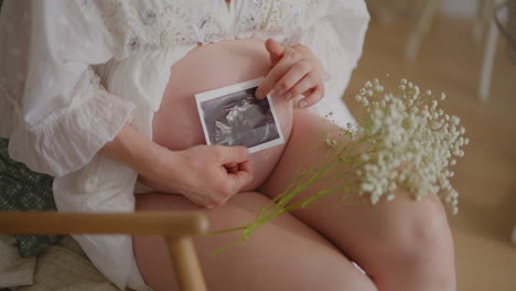close-up ultrasound newborn on pregnant belly