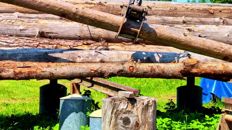 logging claw grabbing and lifting wooden log stacked outdoor. closeup shot
