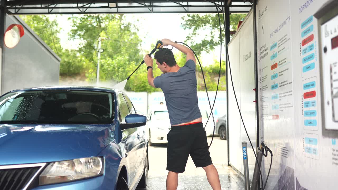 사람이 셀프 서비스 세탁소에서 파란 차를 고 있다