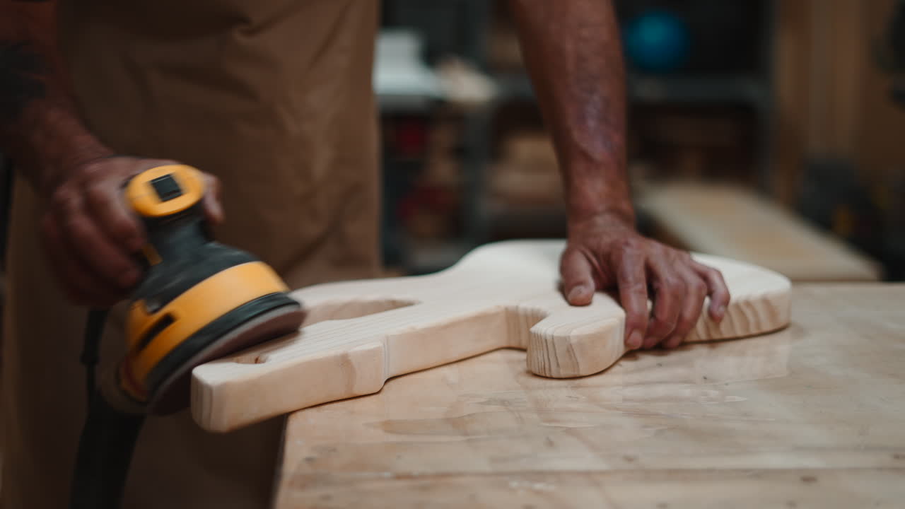 Craftsman Sanding Wooden Electric Guitar Body in Workshop