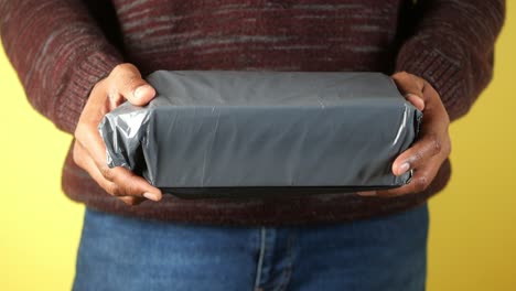 person holding a wrapped gray box