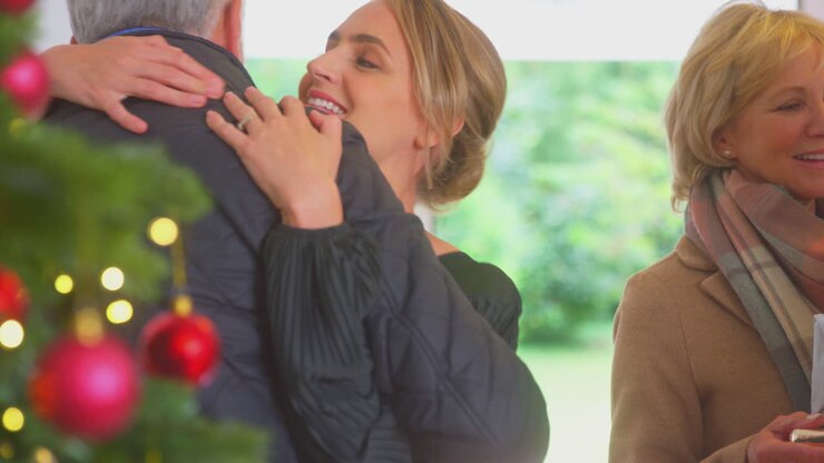 Couple Greeting Senior Parents As They Arrive With Presents To Celebrate Christmas