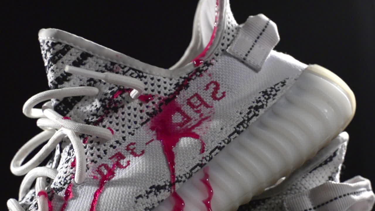 SLOW MOTION dripping red syrub on sneaker and pouring water clean red syrup on waterproof white sneaker , close up