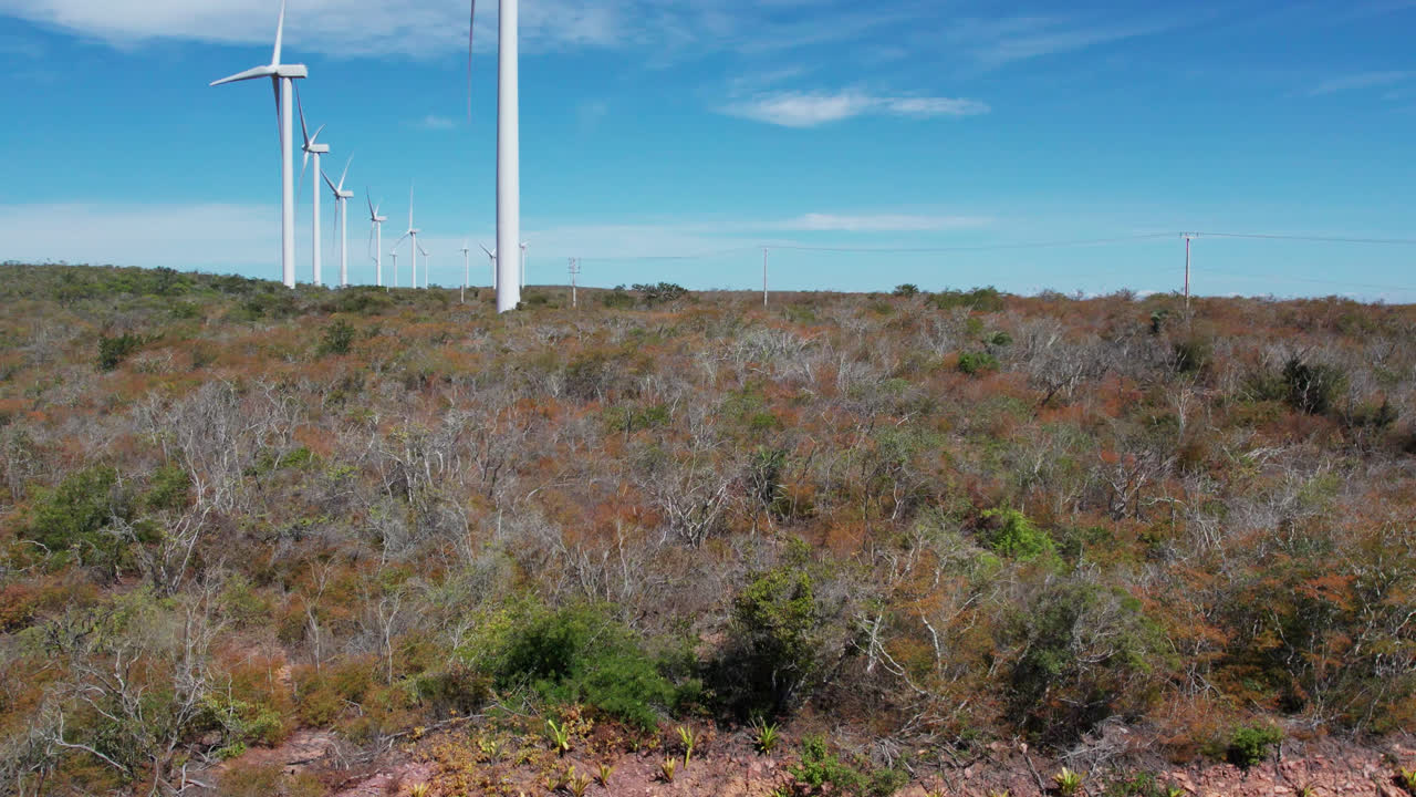 Rural scene with rotating wind turbines shadows in sunny day. Aerial