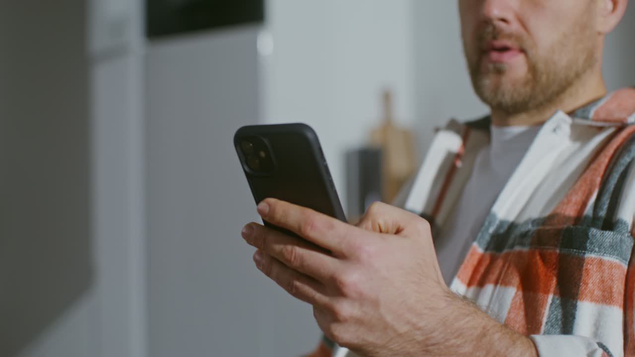 hombre usando teléfono inteligente en la cocina