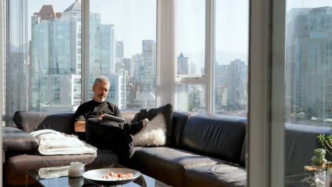 man using digital tablet on sofa 4k