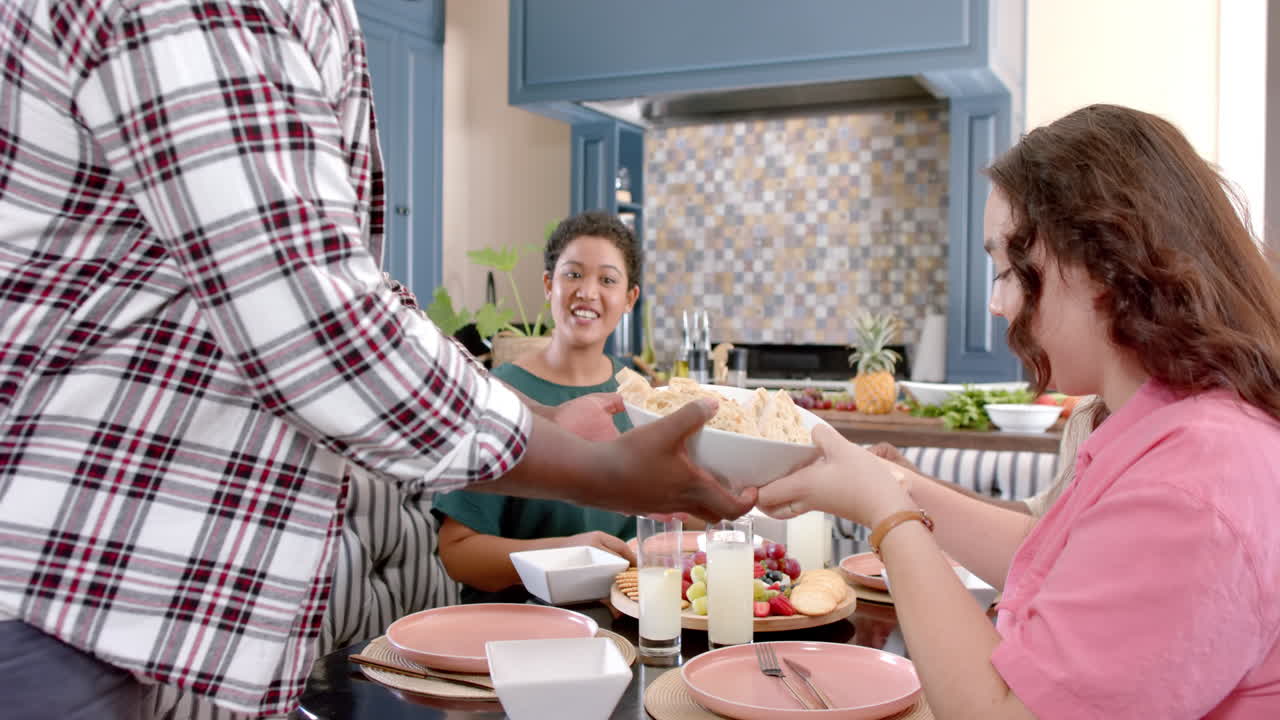 Diverse group of friends sharing meal, enjoying time together in kitchen
