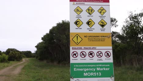 señal de advertencia con información de seguridad en el camino de la playa
