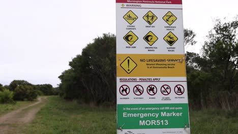 warning sign with safety information at beach pathway