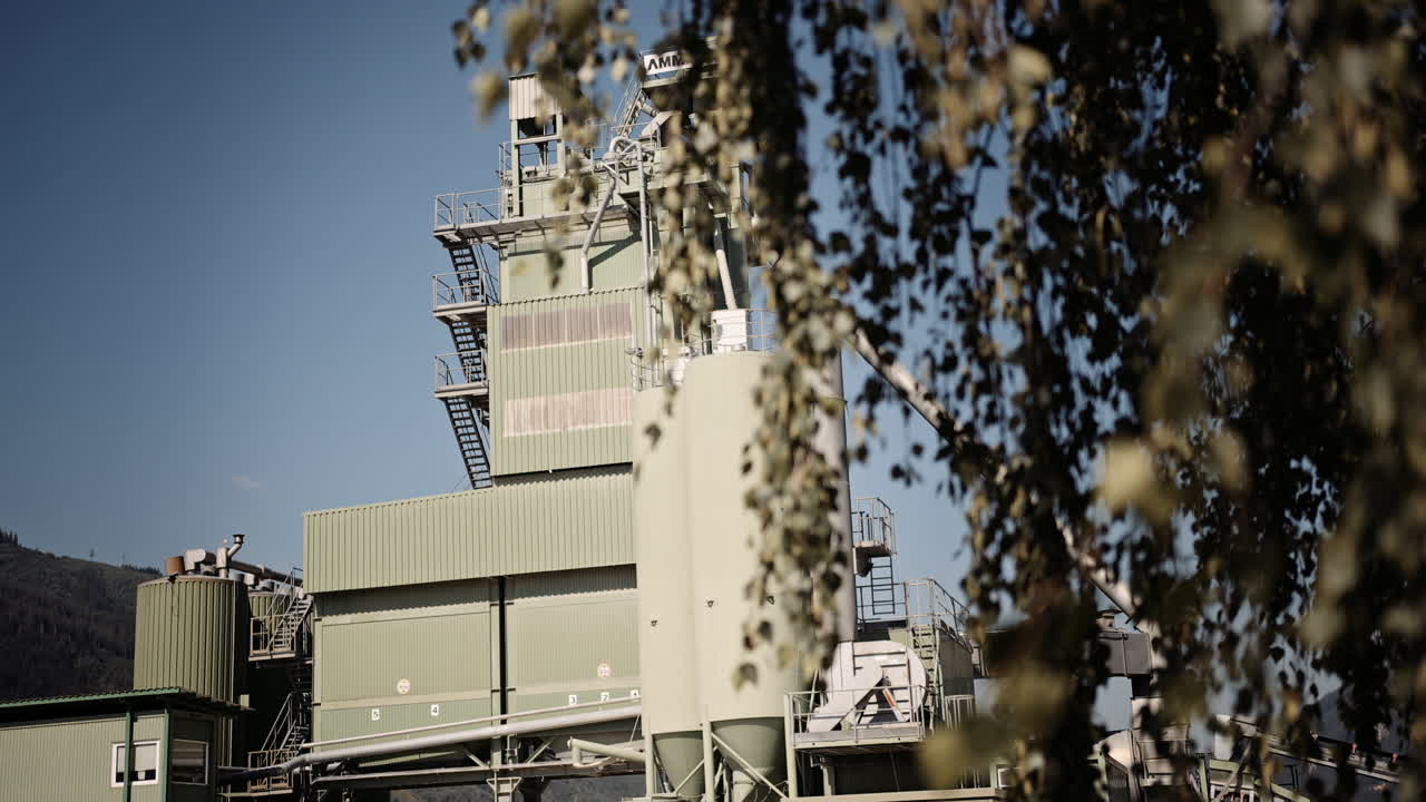 나무 뒤에 공장 건물