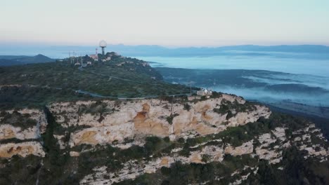 4k-Drohnenaufnahme-Einer-Klippe-Auf-Mallorca-Am-Morgen-Mit-Morgennebel-überall---Balearen-Spanien---Santuari-De-Cura