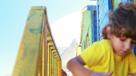 Boy-using-digital-tablet-near-colorful-beach-hut