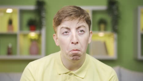 close-up of young man looking at camera thoughtfully.