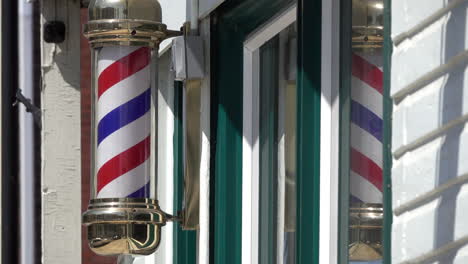 close-up of turning barber pole with reflection in window