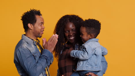 African-american-positive-couple-doing-peek-a-boo-with-their-young-child