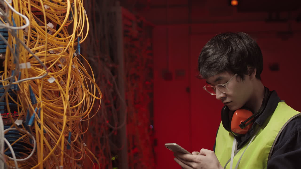 IT Administrator Making Photo of Wires in Data Center