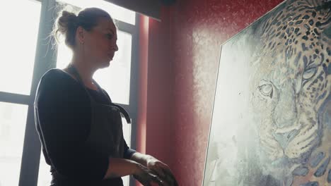 artist viewing a painting of a leopard