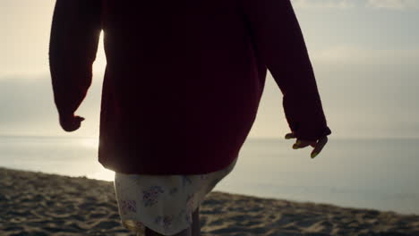 mujer de moda en primer plano caminando por la playa. chica pasando el tiempo libre en el océano