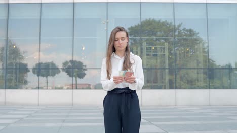 european young corporate woman taking out a wad of bills and counting the payment money