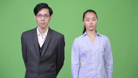 young asian business couple looking away together