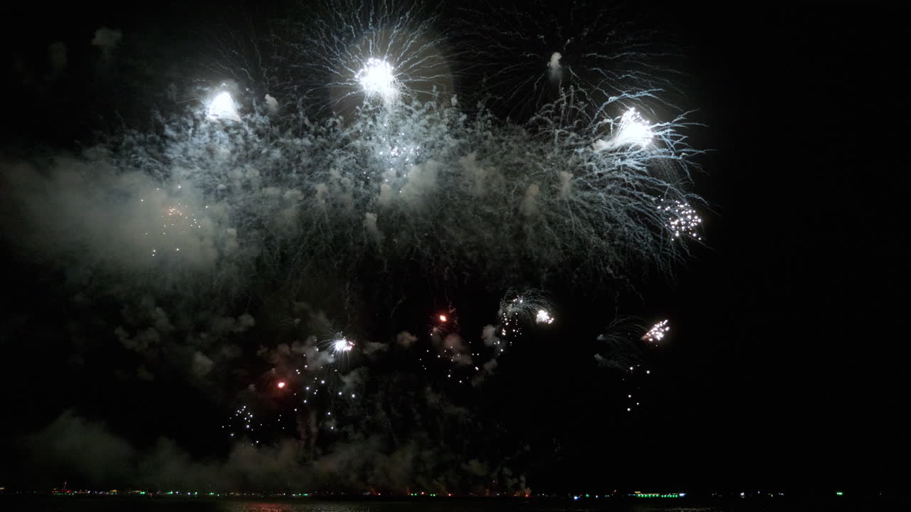 explosiones blancas como nubes, fuegos artificiales de color plateado y en la parte inferior algunas pequeñas secuencias