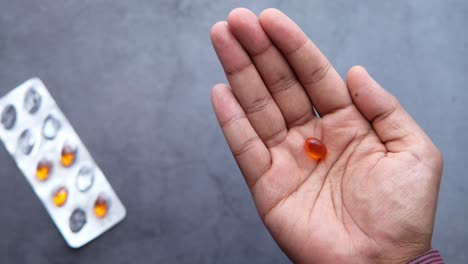 person holding orange pills