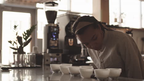 female barista sniffing different coffee types