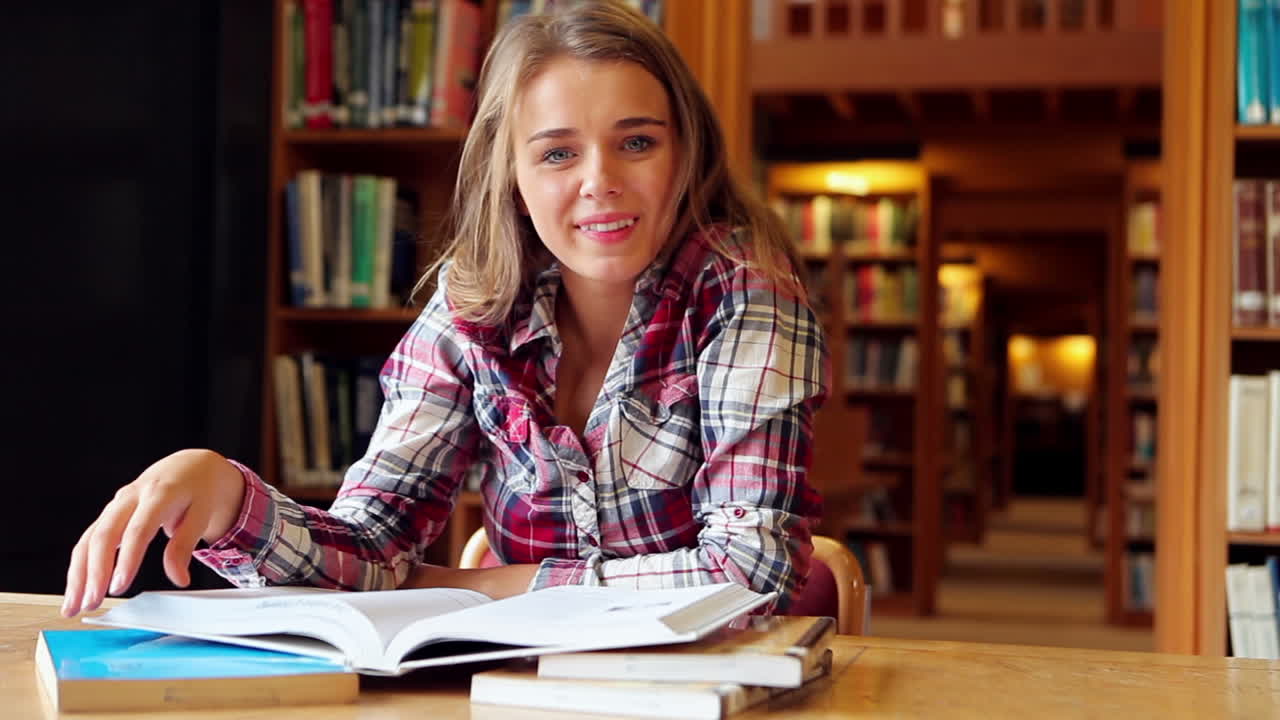 Happy student studying at desk in the library