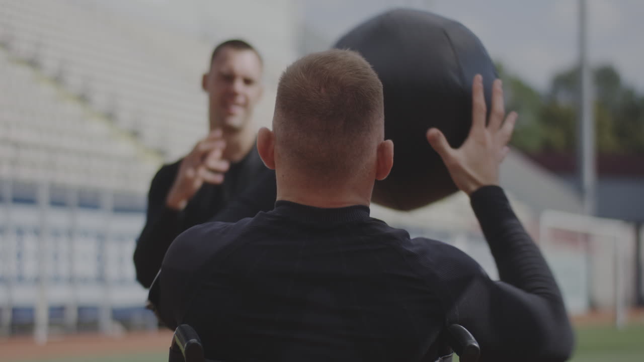 Athlete in Wheelchair Receiving Support During Practice
