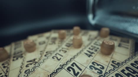 grúa al revés de un juego de lotería de mesa de bingo, tarjetas antiguas con números, fichas de madera, cámara súper lenta 120 fps, luces de estudio