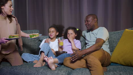 kids with parents watching film at home