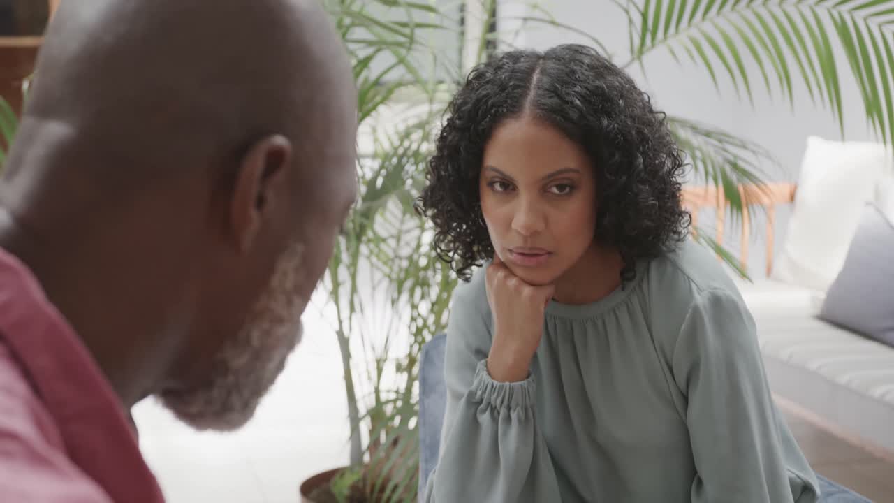 Diverse male therapist and female patient talking in therapy session, slow motion