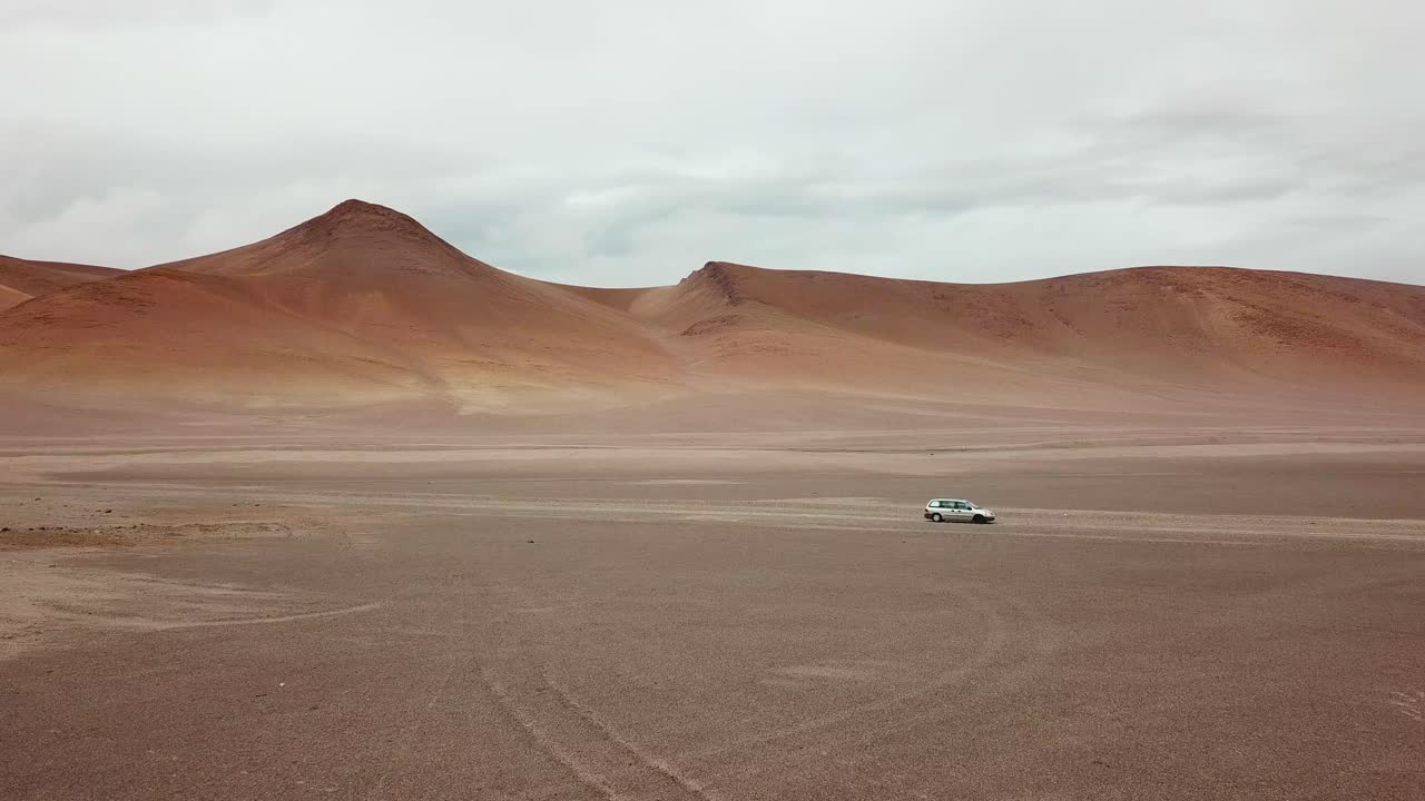 Solitary Vehicle on Dusty Road on Atacama Desert Slopes, Aerial View of Surreal Dry Landscape