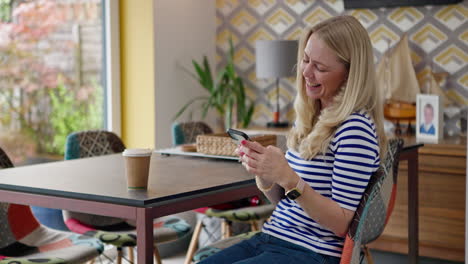 a woman uses her phone at the table