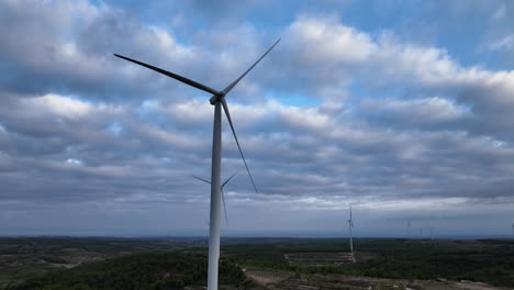 complex aerial reveal shot of static windmills in windfarm area with beautiful dramatic clouds