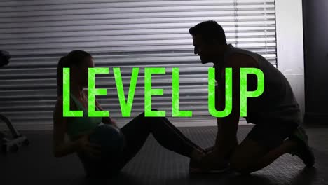 animación de texto de nivel en letras verdes sobre una mujer haciendo abdominales con un instructor masculino