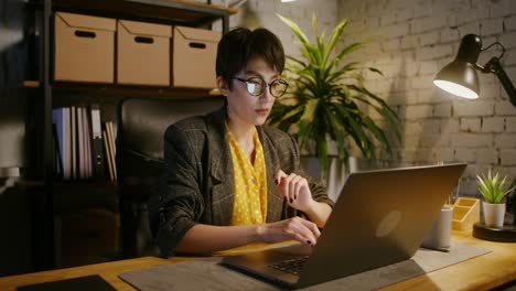 mujer trabajando tarde en la noche en la computadora portátil