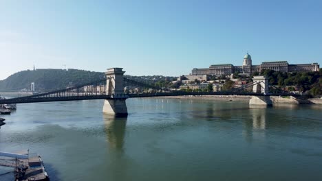 drone view over danube of széchenyi chain bridge and iconic buda castle, hungary