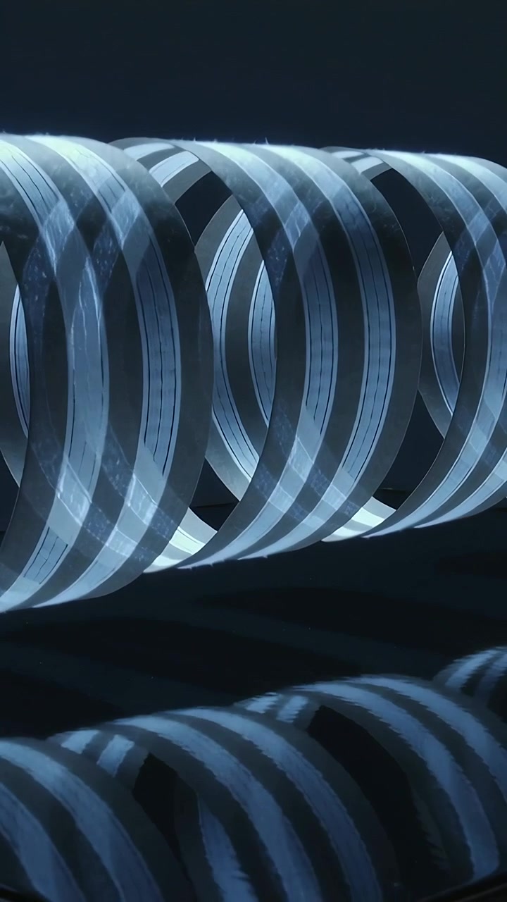 Vertical video: Shifting camera revealing striped rings under light in studio, showing mirror base