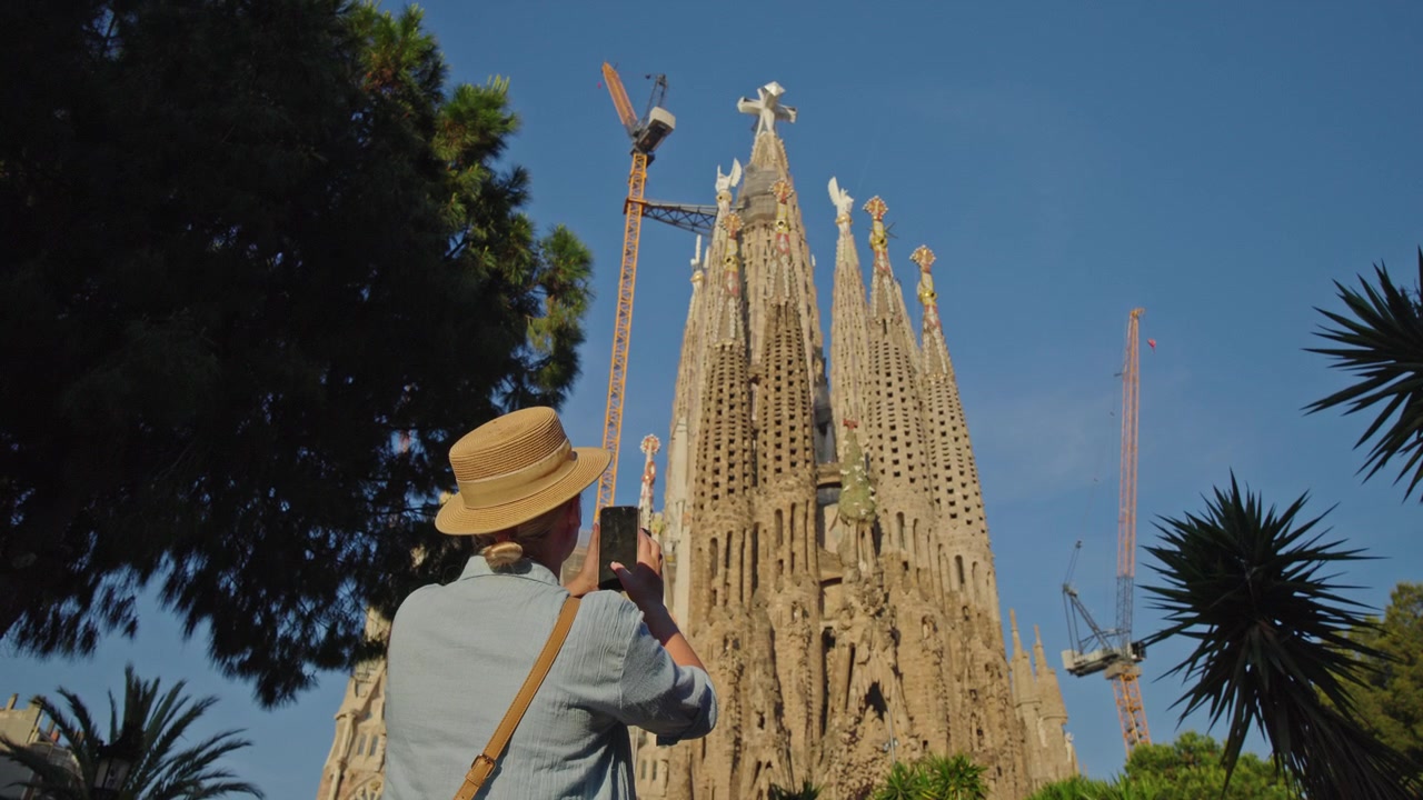 Donna che fotografa la Sagrada Familia con lo smartphone