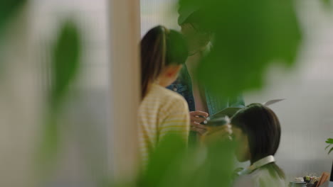 Grupo-De-Empresarios-Diversos-Reuniéndose-Con-La-Líder-Del-Equipo-Pelirroja-Mujer-Compartiendo-Documentos-Del-Proyecto-Estudiantes-Creativos-Trabajando-Juntos-Intercambiando-Ideas-En-Un-Colorido-Lugar-De-Trabajo-De-Oficina