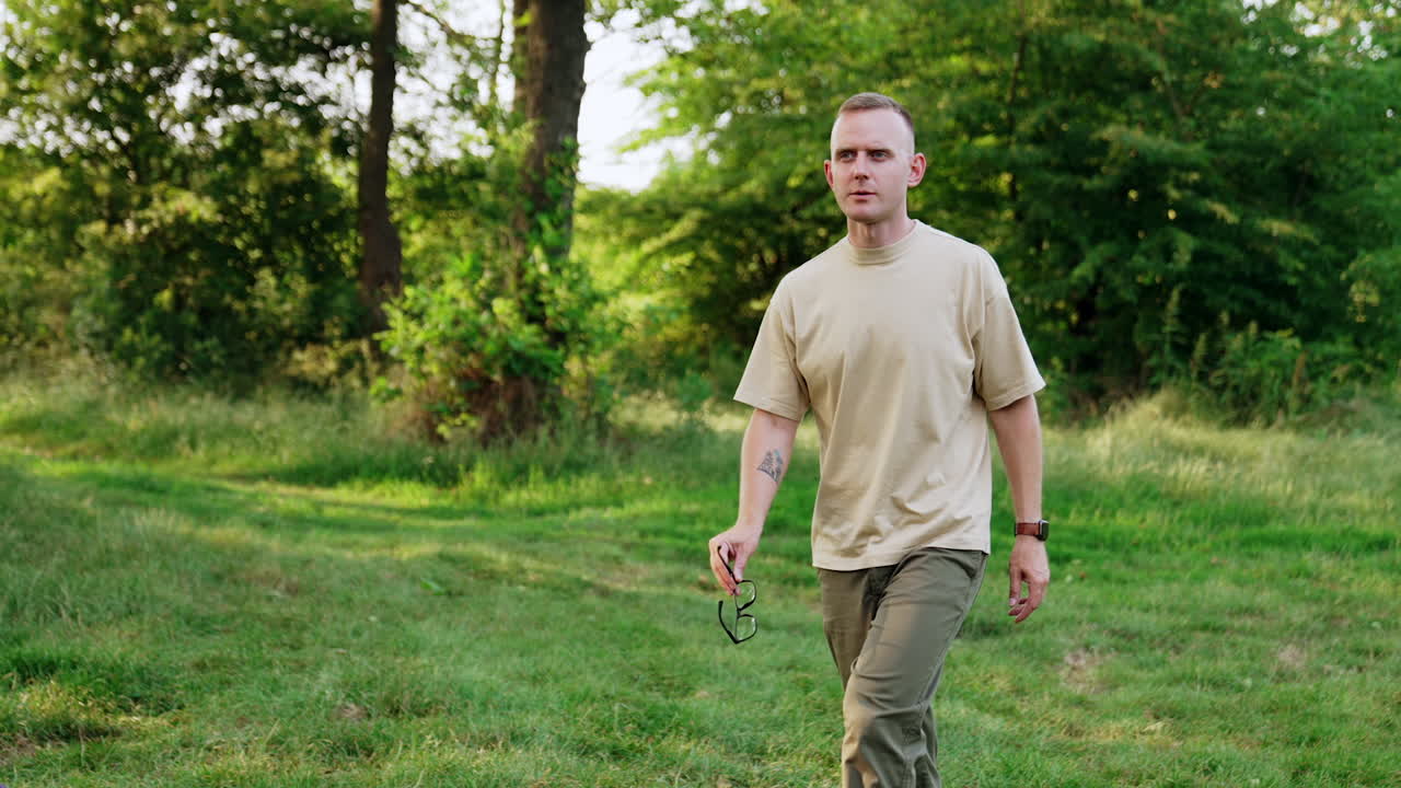 Caucasian male in casual clothes walks in the forest. Man comes up to his car trunk, sits down and starts work on laptop.