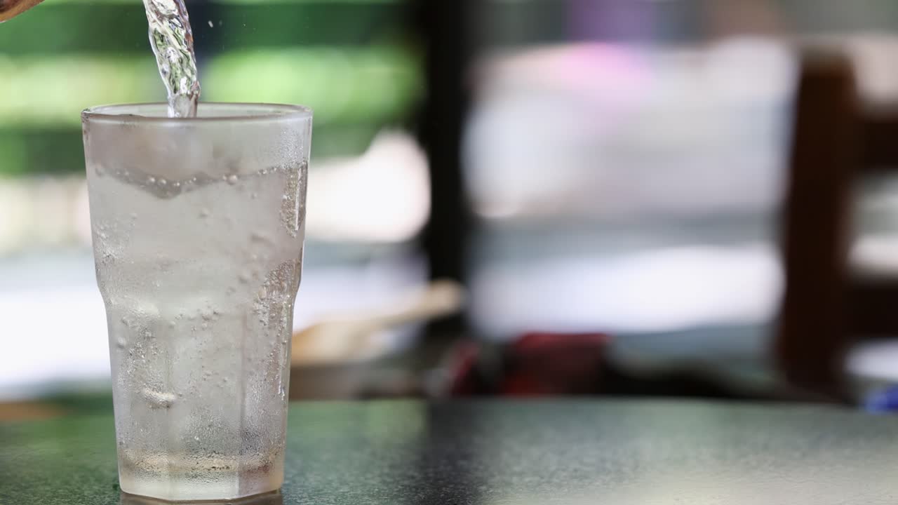 상쾌한 소다가 유리잔에 부어, 밝고 캐주얼한 환경에서 거품과 거림을 만니다.