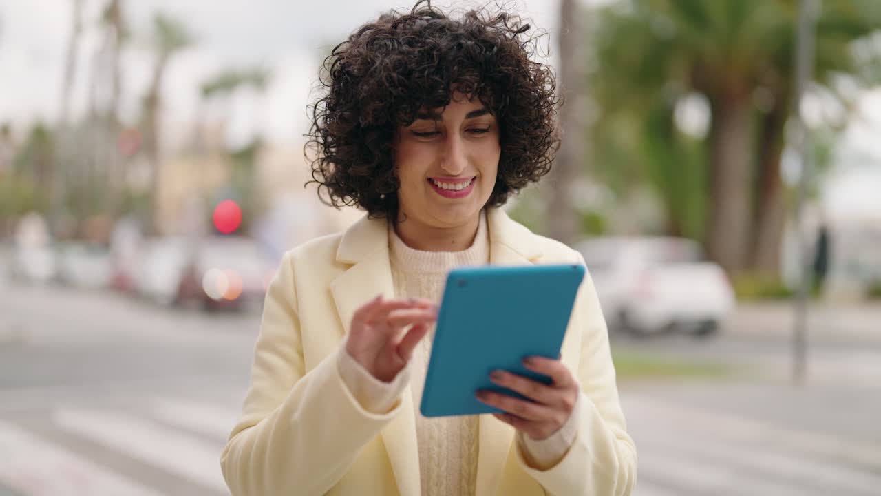 mujer joven sonriendo confiada usando el touchpad en la calle