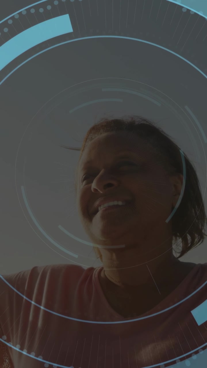 Senior woman turning, raising arms as dots appearing, starting blue HUD around torso for technology