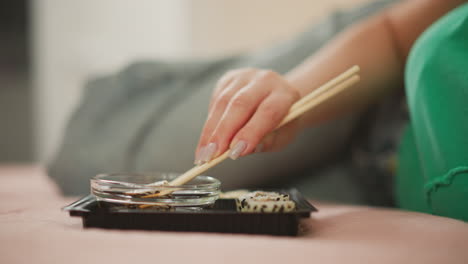 woman eating sushi in bed