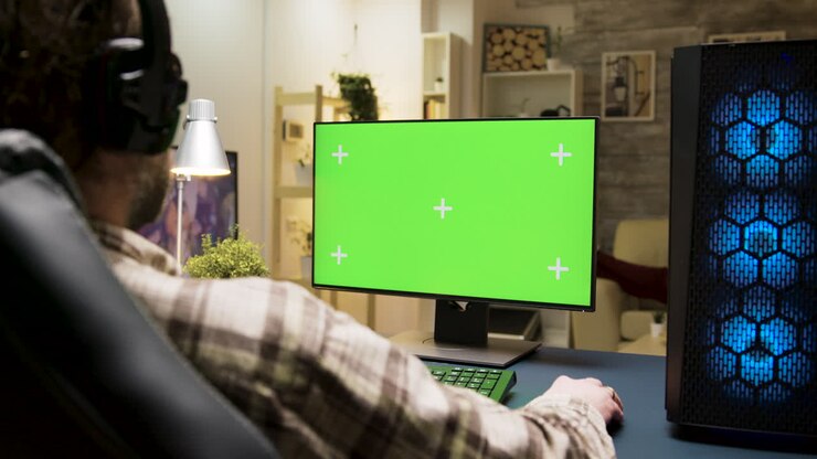 Mand, der spiller computerspil på computer med grøn skærm